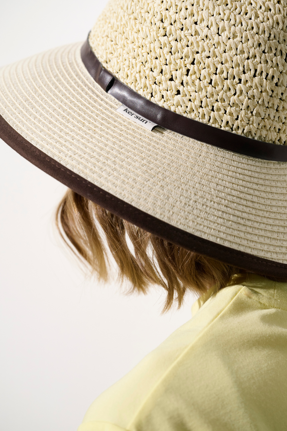Chapeau anti-UV - Antibes, beige avec large bord, offrant une protection solaire UPF 50+, porté par une femme.