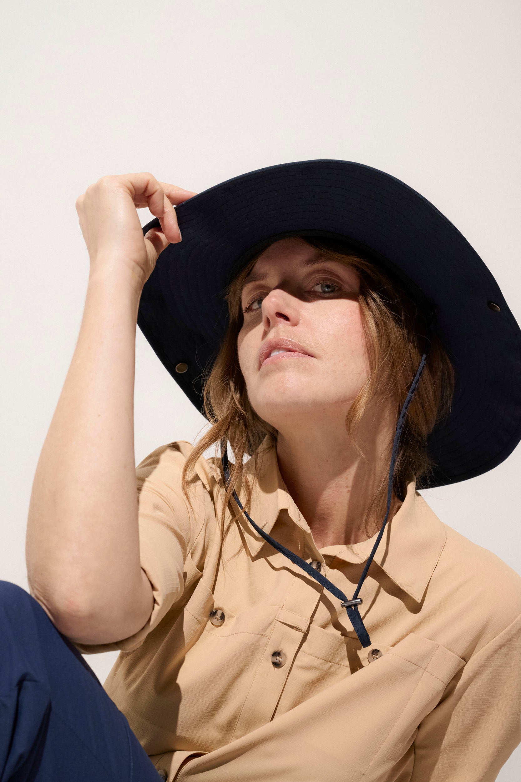 Chapeau anti-UV noir UPF50+ pour femme, léger et pratique, idéal pour randonnées en pleine nature.