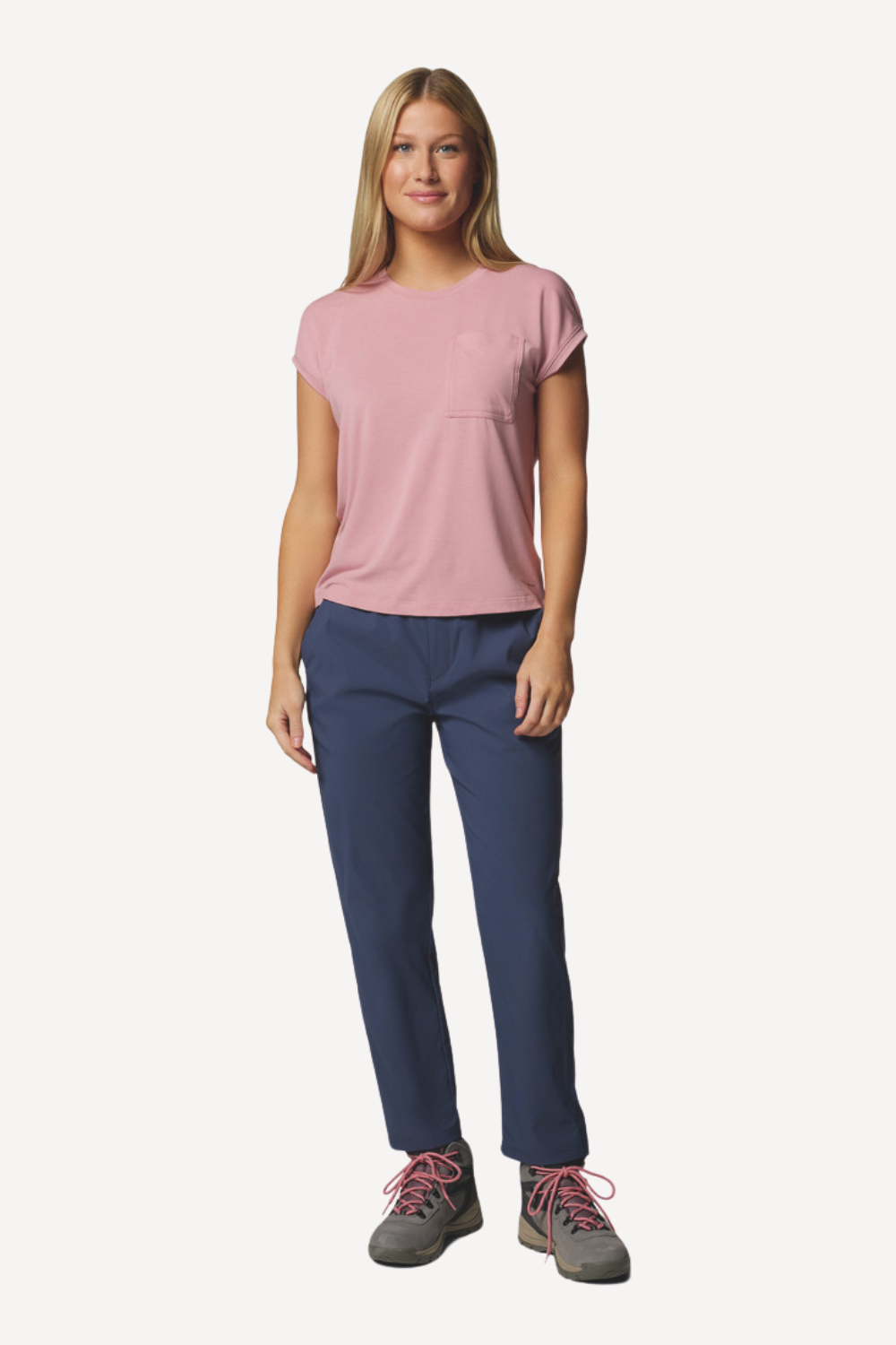 Femme portant un pantalon anti-UV bleu et un t-shirt léger rose, idéal pour les activités de plein air et protection solaire.