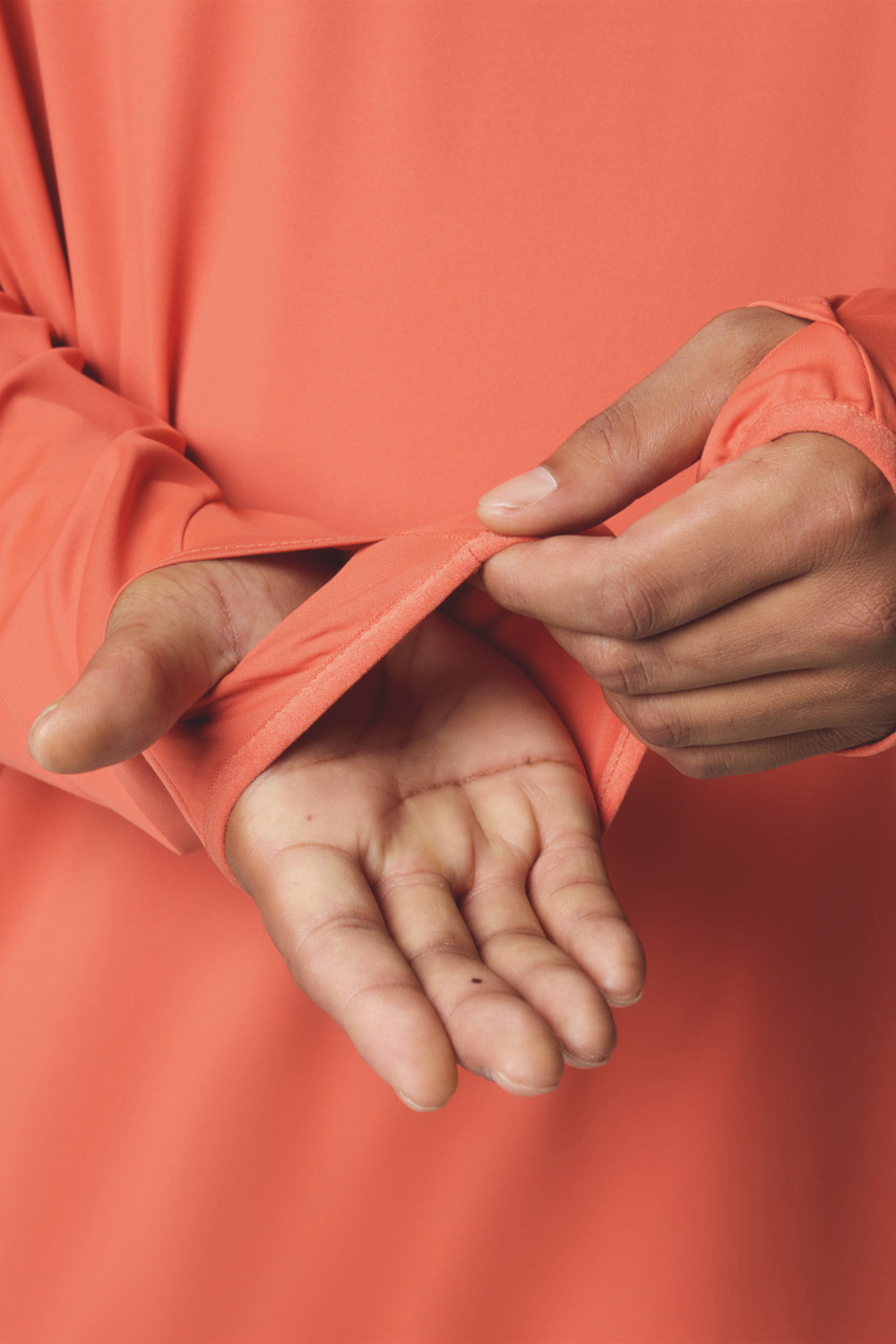 Homme portant un sweat-shirt anti-UV orange avec manches longues, protection solaire UPF 50+.