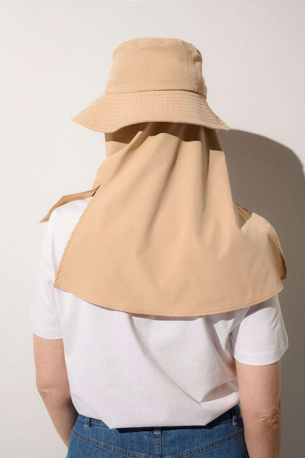 Bob anti-UV beige porté par une femme, idéal pour la protection solaire lors d'activités en extérieur.