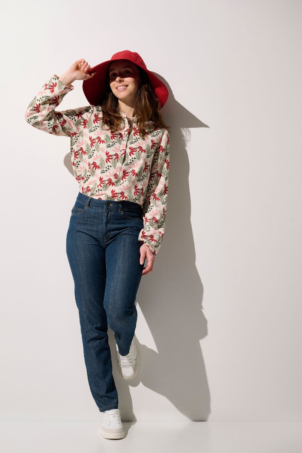 Femme portant une blouse anti-UV - Positano colorée avec chapeau, idéale pour la protection solaire.