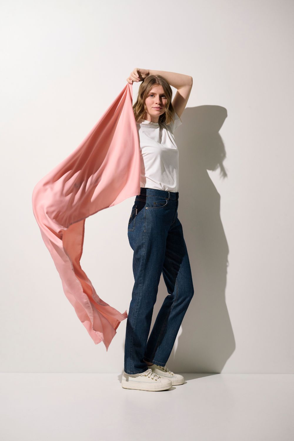 Étole anti-UV - Positano rose portée par une femme en t-shirt, ajoutant une touche de protection solaire élégante.