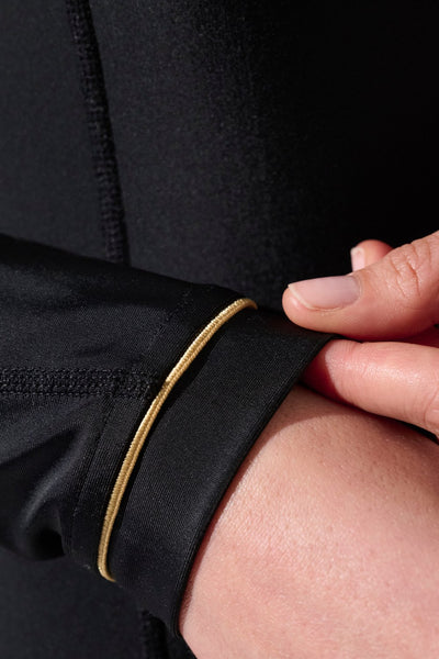 Maillot de bain anti-UV une pièce femme avec manches longues pour une protection solaire efficace des bras et épaules.