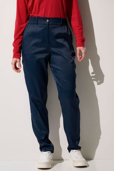 Pantalon anti-UV - Faro, élégant et léger, UPF 50+, porté par une femme en rouge, idéal pour les activités en extérieur.