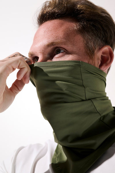 Tour de cou anti-UV - Boston en vert, homme ajustant son vêtement pour une protection solaire confortable.