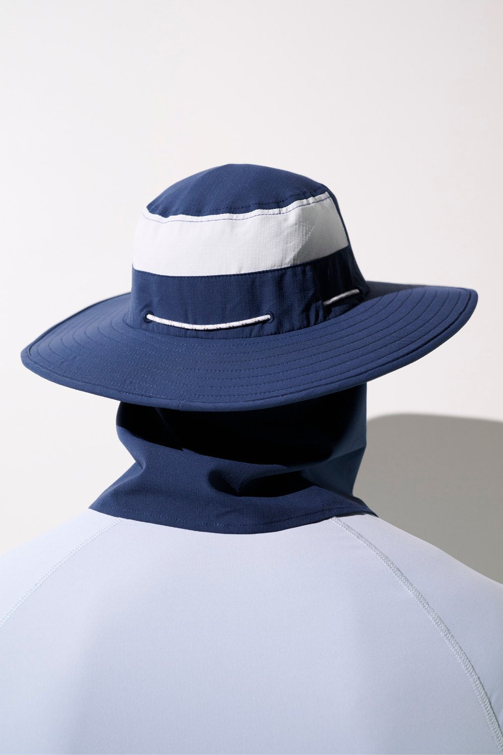 Chapeau anti-UV - Oasis bleu marine avec bande blanche, léger et respirant pour la protection solaire.