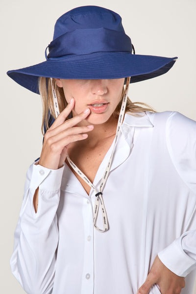 Chapeau anti-UV bleu pour femme, offrant protection solaire élégante avec jugulaire réglable.