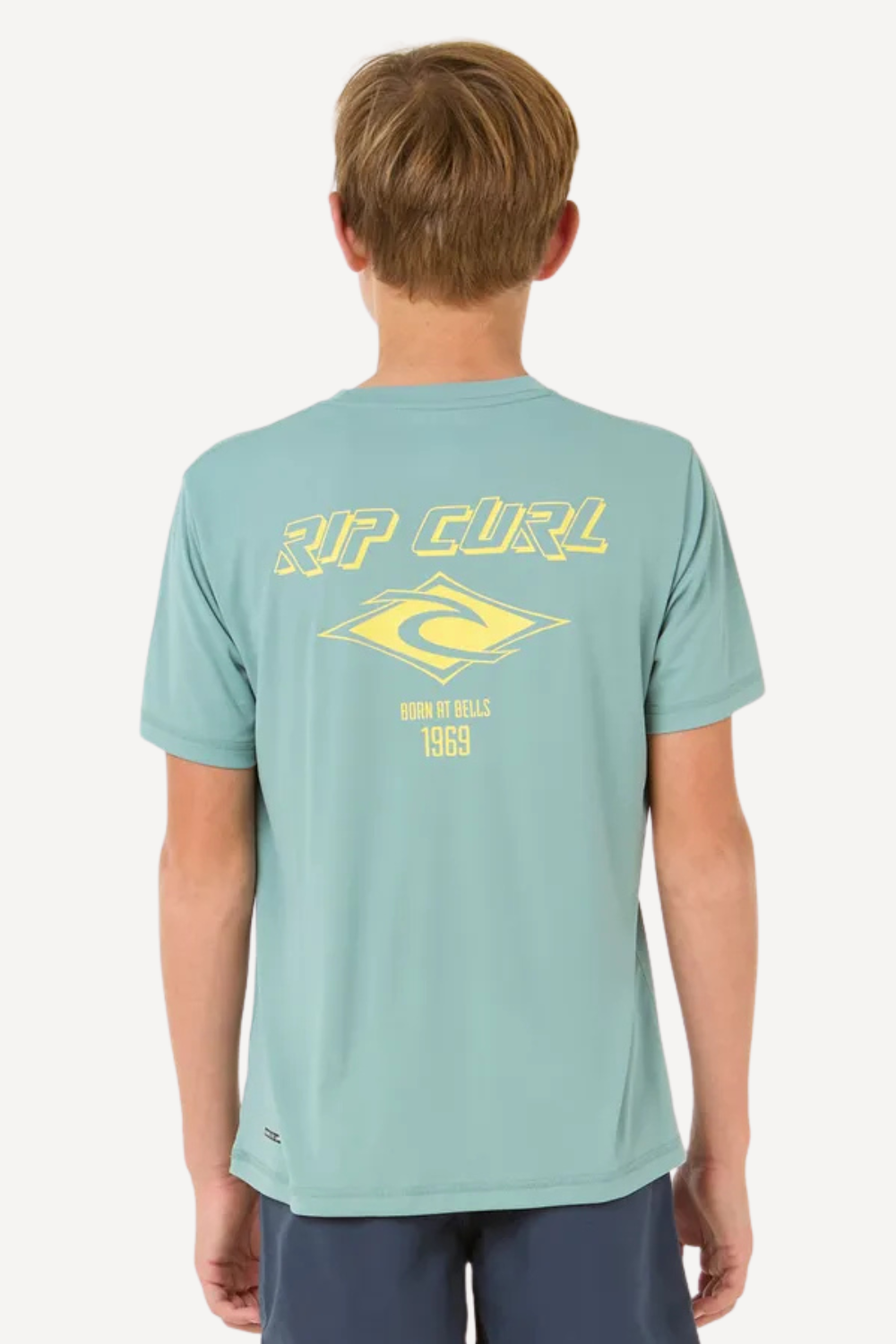 T-shirt anti-UV bleu pour garçon, léger et stylé, avec logo Rip Curl, idéal pour la plage et sports aquatiques.
