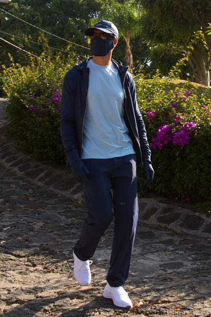 Homme portant un pantalon anti-UV bleu avec t-shirt léger, idéal pour la protection solaire UPF 50+ lors d'activités extérieures.