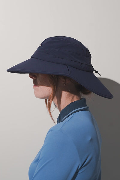 Chapeau anti-UV - Augusta bleu marine UPF 50+ porté par femme, idéal pour le golf et les activités en plein air.