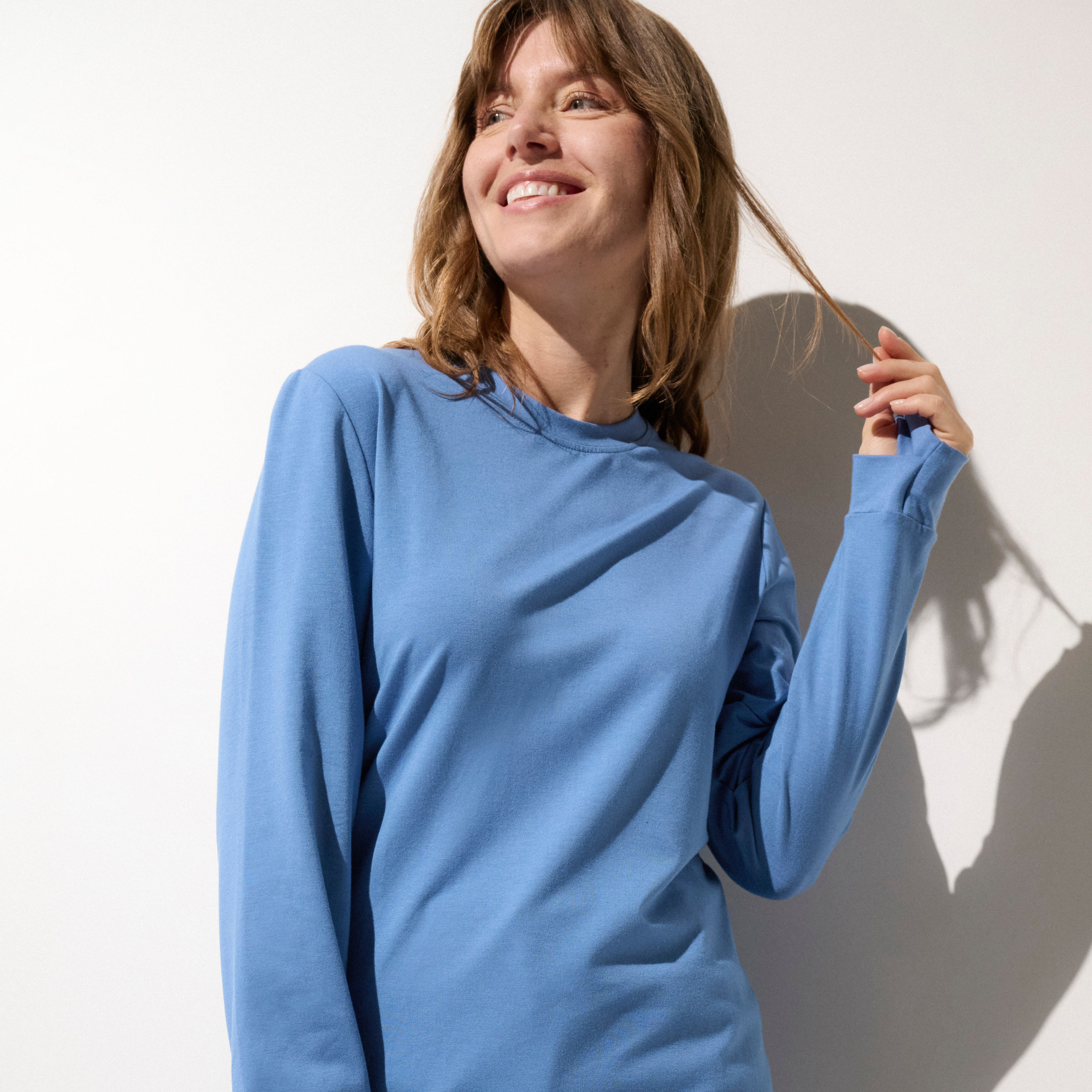 Femme souriante portant un t-shirt anti-UV bleu UPF 50+.